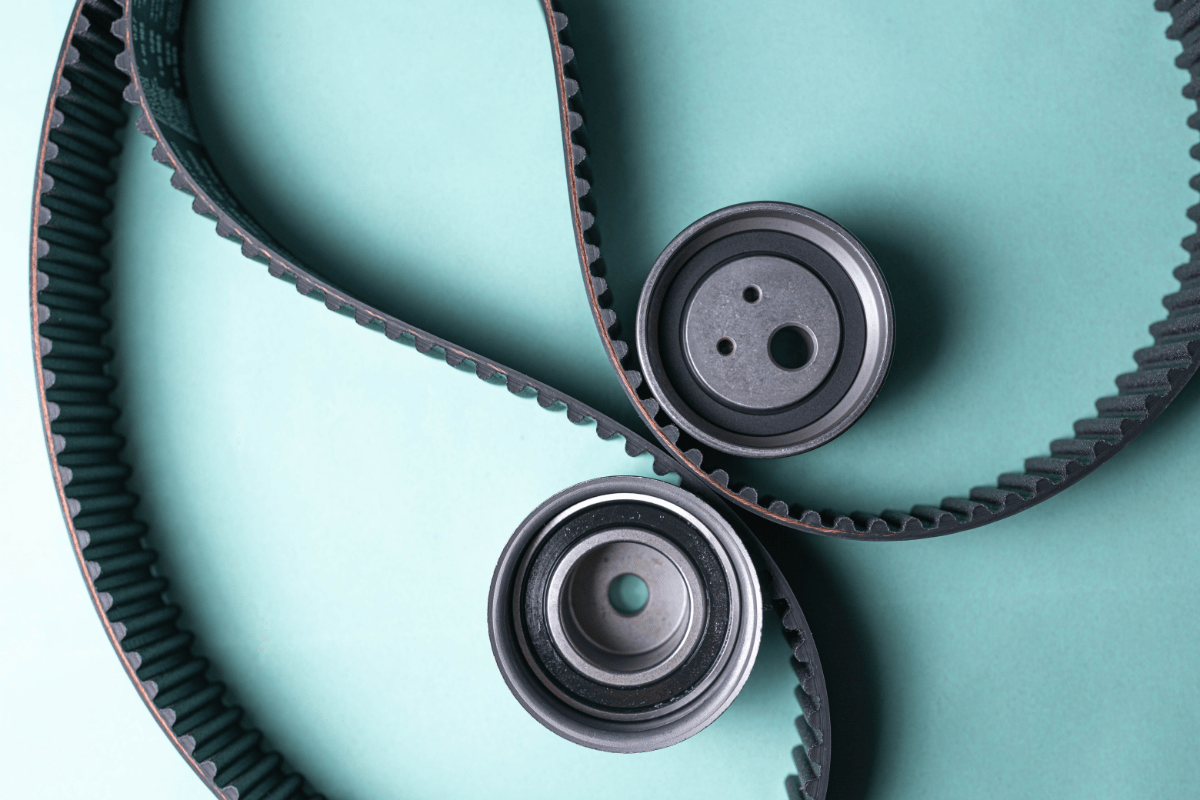 An idler pulley, which is different to a tensioner pulley, next to a new set of timing belts.  